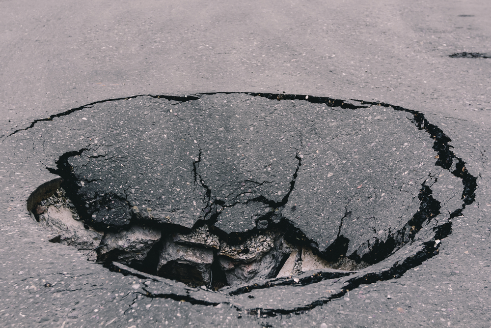 Deep,Sinkhole,On,Asphalt,With,Cracks