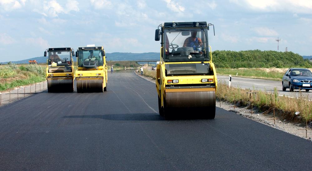 Three pavers driving along a newly paved road